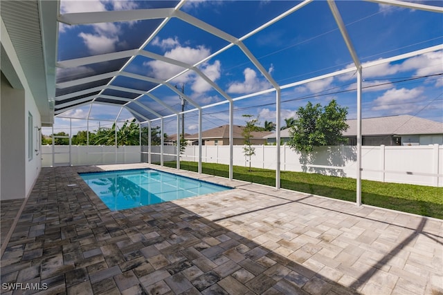 view of pool with a yard, a patio, and a lanai