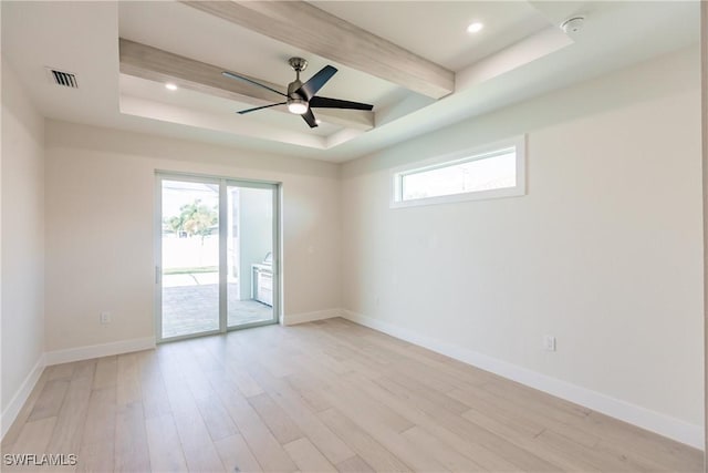 empty room featuring plenty of natural light, light wood-type flooring, visible vents, and baseboards