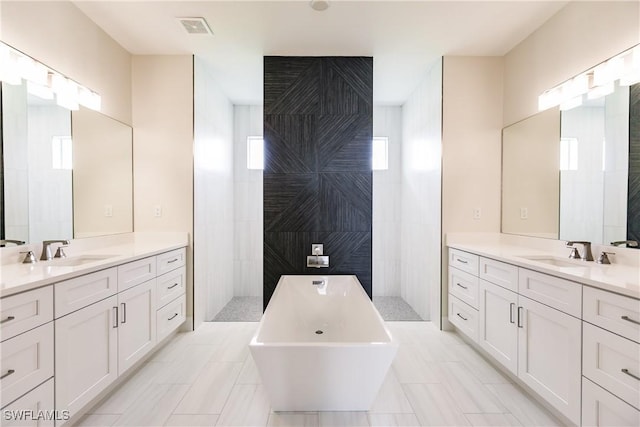 full bath featuring a wealth of natural light, visible vents, and a sink