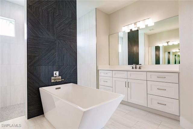 full bathroom with tile walls, a freestanding bath, vanity, and a walk in shower