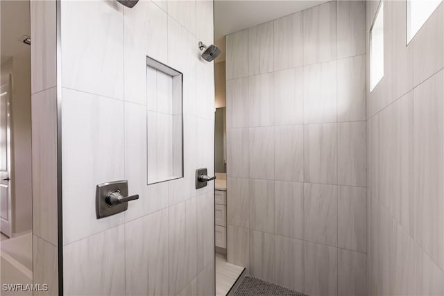 full bathroom featuring a tile shower and tile walls