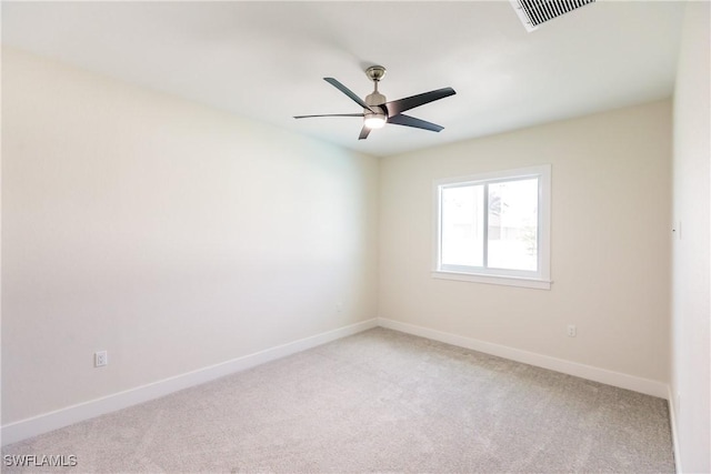 spare room featuring a ceiling fan, visible vents, light carpet, and baseboards