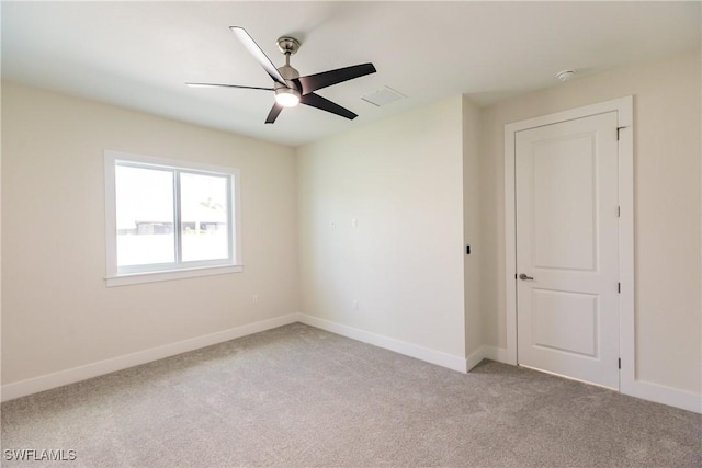 empty room featuring baseboards, a ceiling fan, and light colored carpet