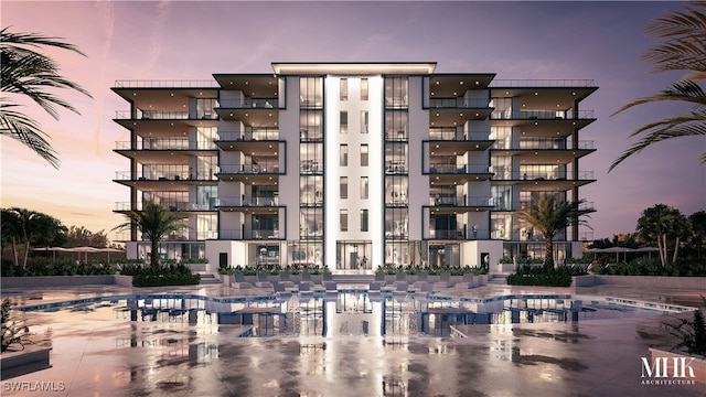 outdoor building at dusk featuring a community pool