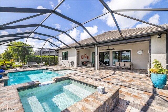 view of swimming pool with glass enclosure, ceiling fan, and a patio