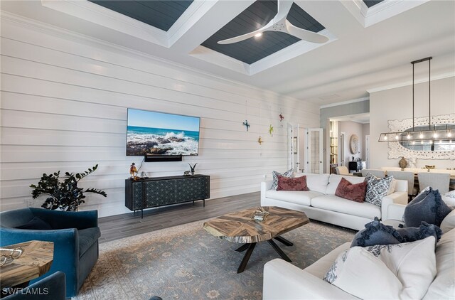 living room featuring dark hardwood / wood-style flooring, ornamental molding, ceiling fan, beam ceiling, and wood walls