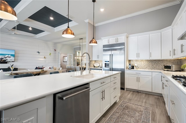 kitchen featuring white cabinetry, hanging light fixtures, and appliances with stainless steel finishes