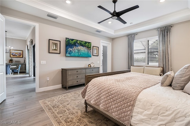 bedroom with ornamental molding, ceiling fan with notable chandelier, and light wood-type flooring