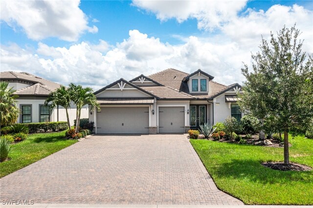 view of front of property with a front yard, french doors, and a garage