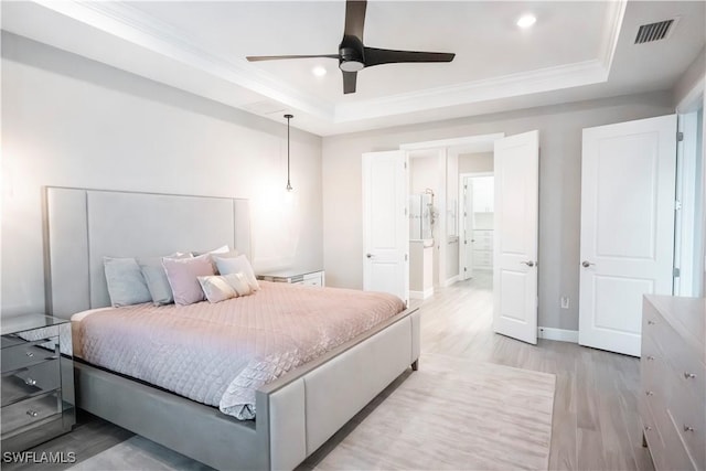 bedroom with a raised ceiling, light hardwood / wood-style floors, ceiling fan, and ornamental molding