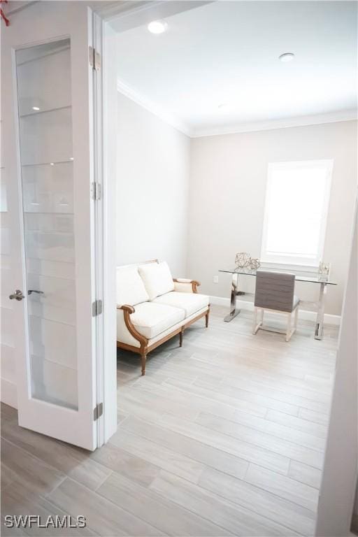 sitting room featuring ornamental molding and light hardwood / wood-style flooring