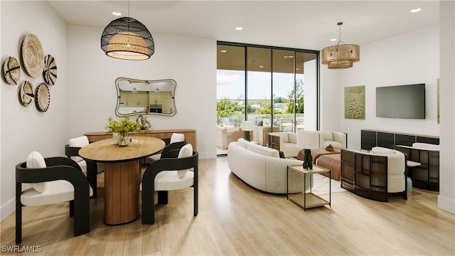 dining area featuring a wall of windows and light wood-type flooring