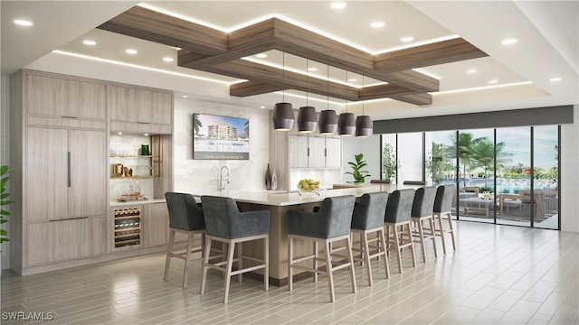 kitchen featuring a breakfast bar, beverage cooler, sink, hanging light fixtures, and a large island