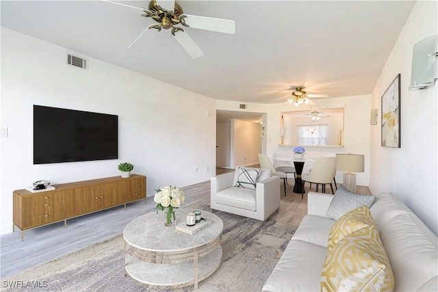 living room featuring hardwood / wood-style floors and ceiling fan