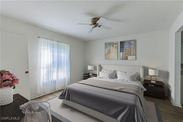 bedroom with dark hardwood / wood-style floors and ceiling fan