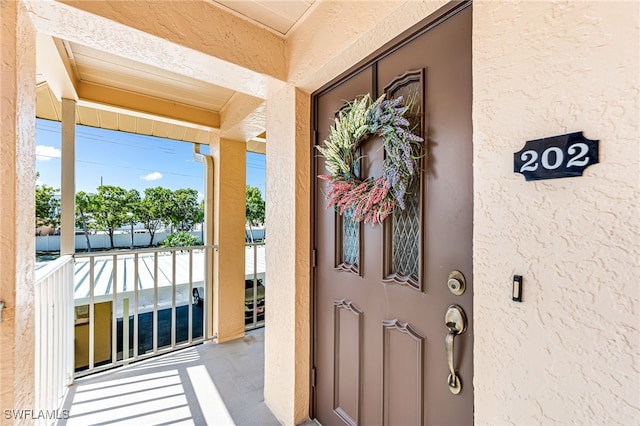 view of exterior entry featuring covered porch