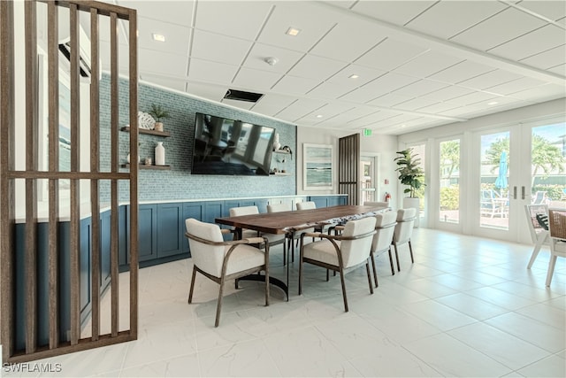 dining space featuring french doors and a paneled ceiling