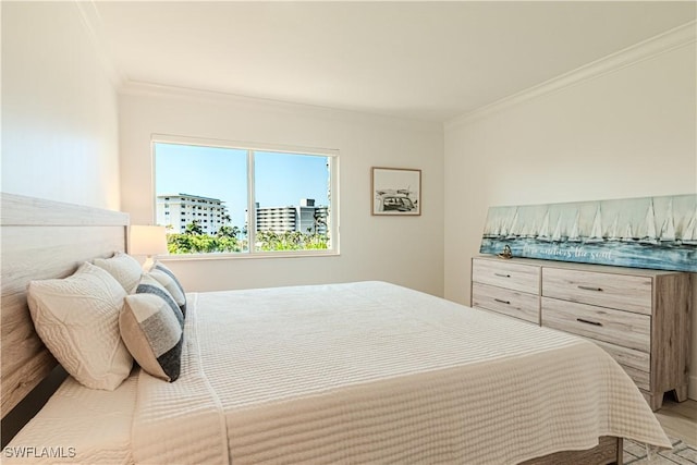 bedroom with crown molding and light hardwood / wood-style floors