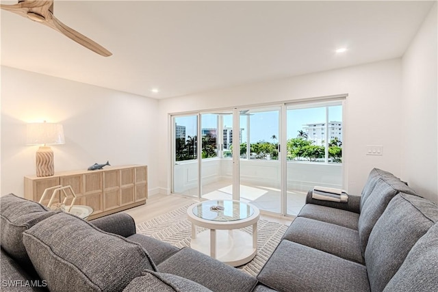 living room with ceiling fan and light wood-type flooring