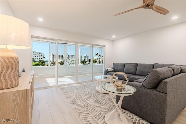 living room featuring ceiling fan and light hardwood / wood-style floors