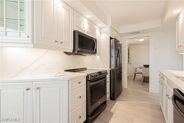 kitchen with light stone counters, decorative backsplash, white cabinets, and appliances with stainless steel finishes