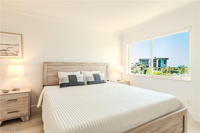 bedroom featuring crown molding and light hardwood / wood-style floors