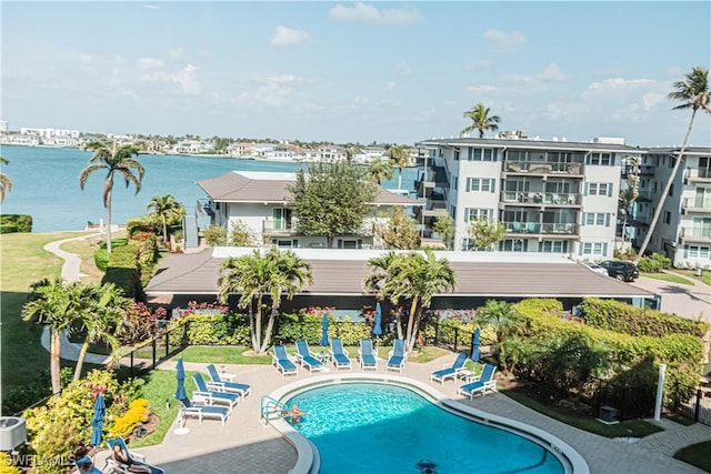 view of swimming pool featuring a water view and a patio area