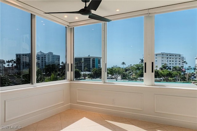 unfurnished sunroom featuring ceiling fan