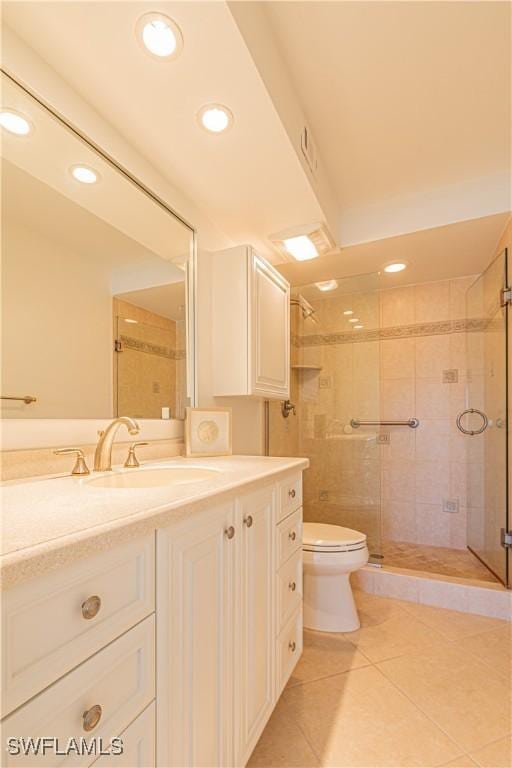 bathroom featuring tile patterned floors, vanity, toilet, and a shower with shower door