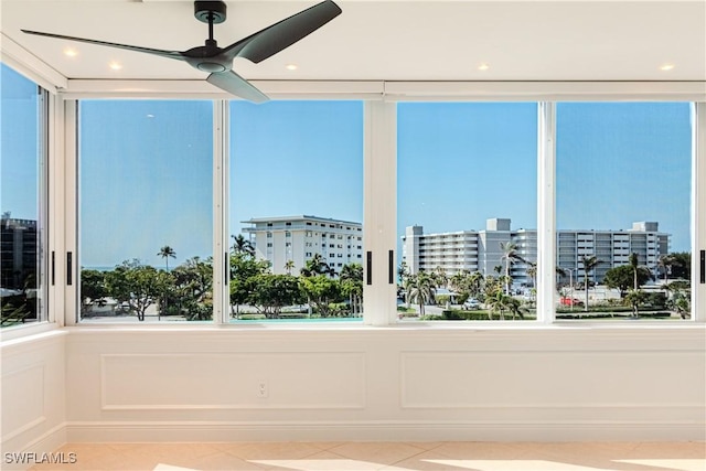 unfurnished sunroom with ceiling fan