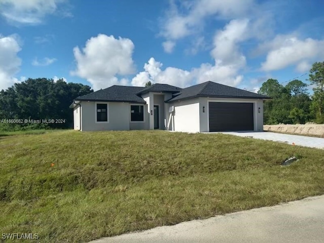 prairie-style home with a garage and a front lawn