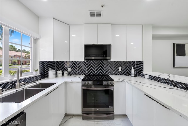 kitchen featuring sink, appliances with stainless steel finishes, white cabinetry, and tasteful backsplash