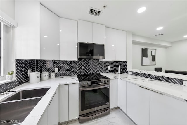 kitchen featuring light stone countertops, tasteful backsplash, stainless steel appliances, sink, and white cabinetry