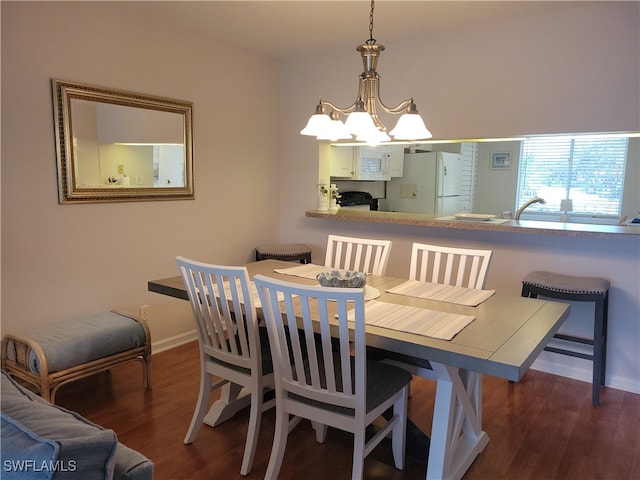 dining space featuring dark hardwood / wood-style flooring, an inviting chandelier, and sink