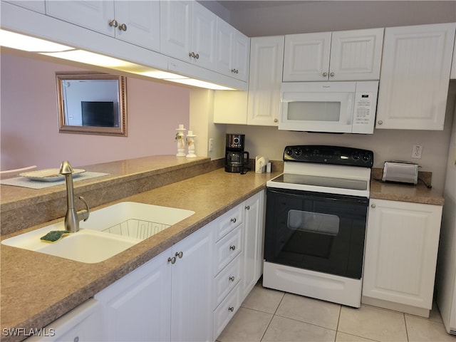 kitchen with light tile patterned floors, white appliances, sink, and white cabinets