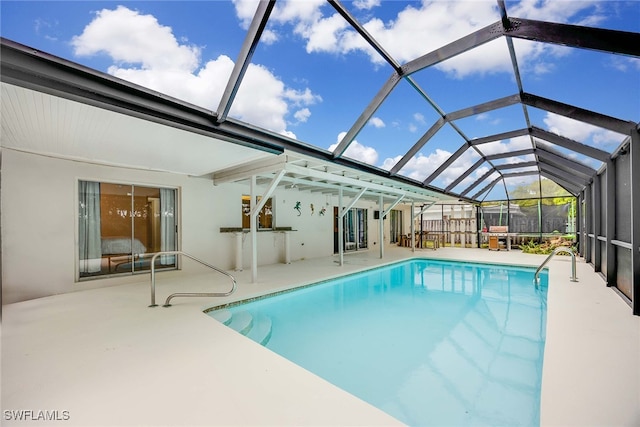 view of swimming pool featuring a lanai and a patio