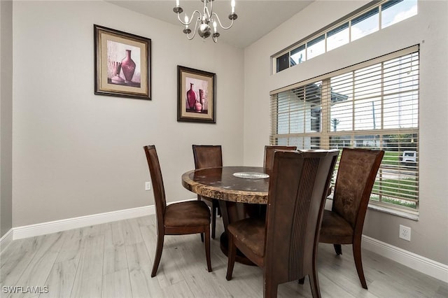 dining room with light hardwood / wood-style floors and an inviting chandelier