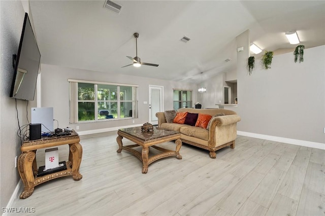 living room with ceiling fan, light hardwood / wood-style floors, and vaulted ceiling