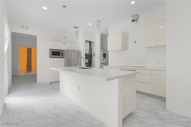 kitchen with stainless steel appliances, an island with sink, hanging light fixtures, and white cabinets