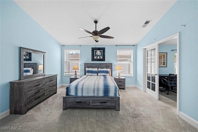 carpeted bedroom featuring lofted ceiling, a textured ceiling, french doors, and ceiling fan