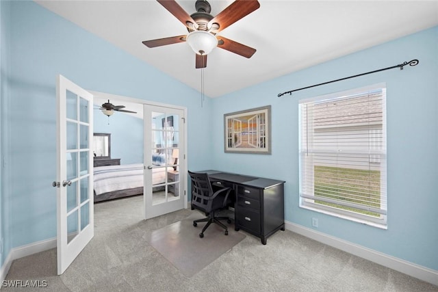 carpeted home office featuring vaulted ceiling, ceiling fan, and french doors