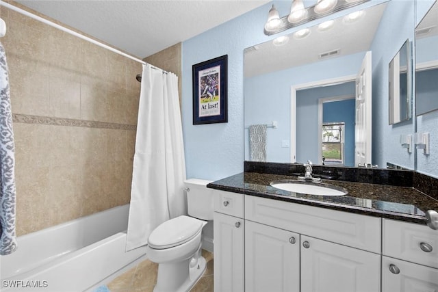 full bathroom featuring shower / bath combination with curtain, vanity, toilet, and a textured ceiling