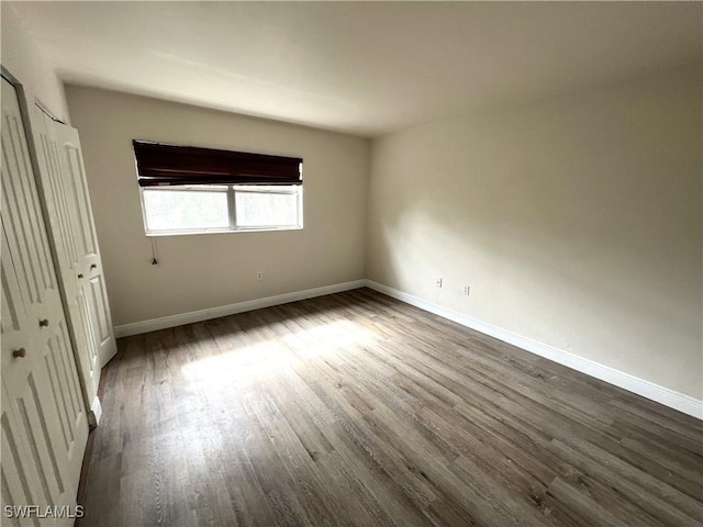 unfurnished bedroom featuring a closet and dark hardwood / wood-style flooring