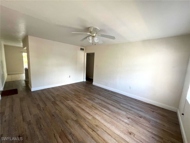 spare room featuring dark hardwood / wood-style flooring and ceiling fan