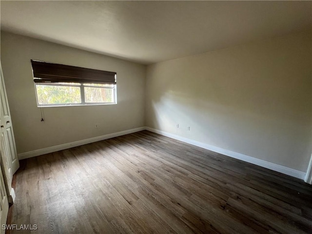 unfurnished room with dark hardwood / wood-style flooring