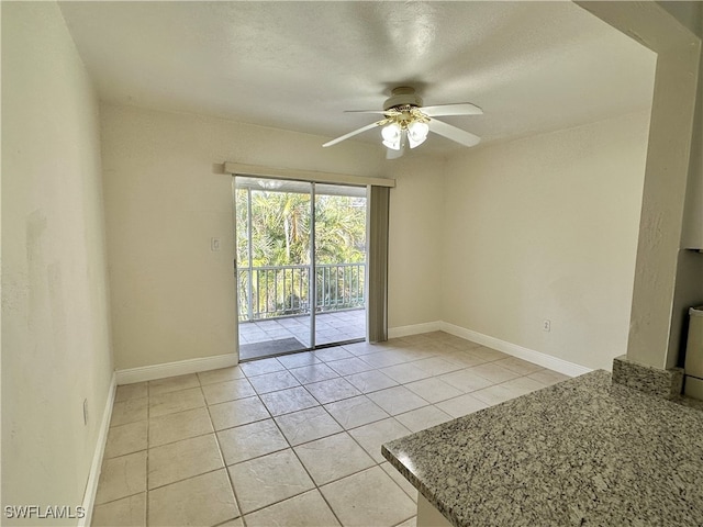 tiled empty room featuring ceiling fan