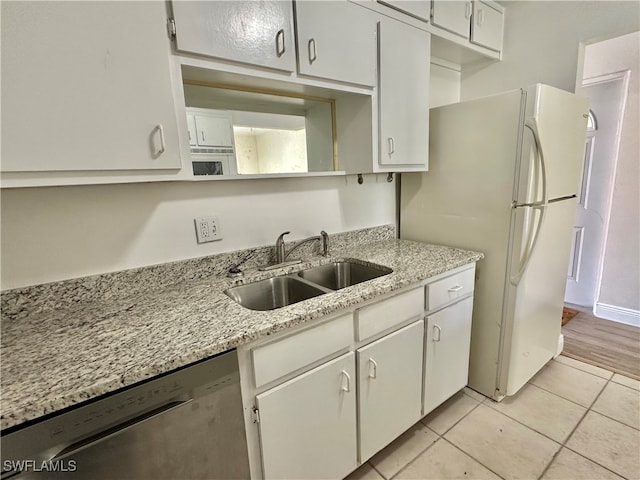 kitchen with white cabinetry, dishwasher, sink, white fridge, and light tile patterned floors