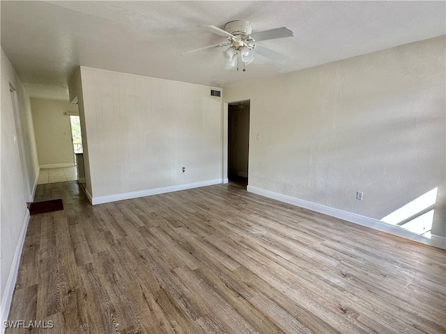 empty room with light hardwood / wood-style flooring and ceiling fan