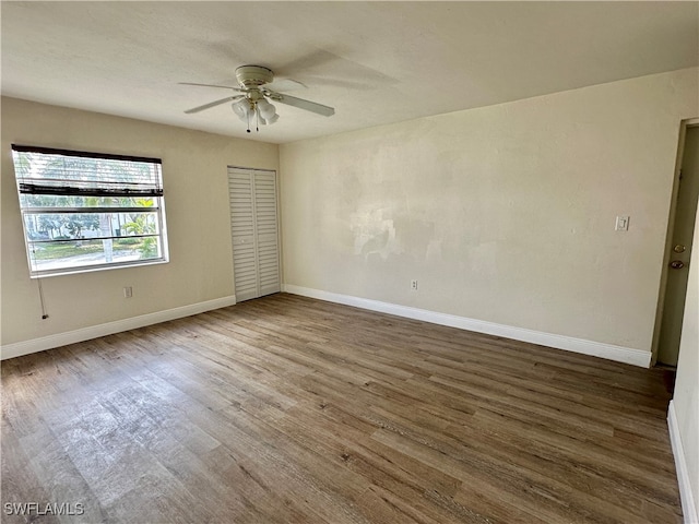 spare room with dark hardwood / wood-style floors and ceiling fan