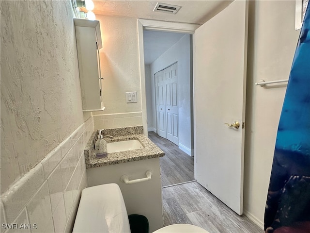 bathroom featuring vanity, wood-type flooring, and toilet